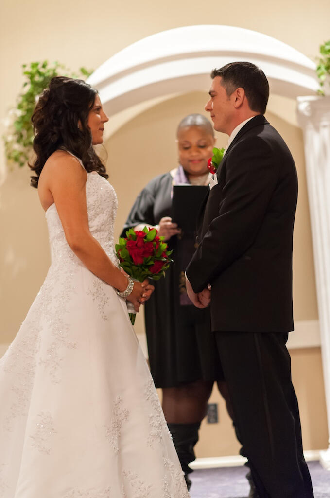 Nikki Officiating for Missy and Frank A couple facing each other in front of the alter with the officiant in the background.