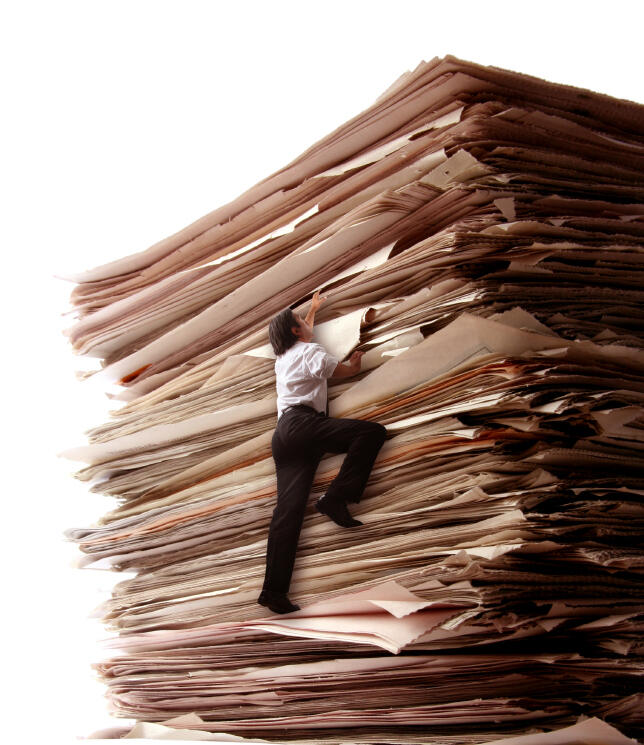 Woman on paper pile Woman climbing a giant stack of papers